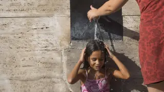 Una joven se refrescaba ayer en una de las fuentes de la Plaza del Pilar para soportar el calor. Toni galán