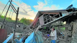 Una mujer contempla las ruinas de un edificio alcanzado por los bombardeos rusos.