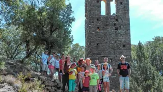 Un grupo de excursionistas, junto a la atalaya, en ruinas.