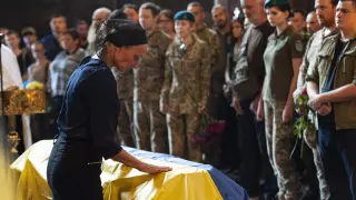 La madre de un militar ucraniano acaricia el féretro de su hijo, fallecido en los enfrentamientos con las tropas rusas en la región de Donbás
