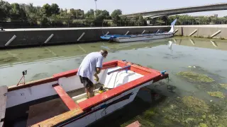 Pablo Polo, terminando de achicar agua de una de las embarcaciones que hundieron los vándalos.