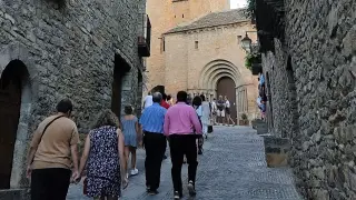 Turistas paseando por las calles de la villa medieval de Aínsa.