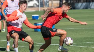 Carrillo controla el balón marcado por Escriche durante un entrenamiento de la SD Huesca.