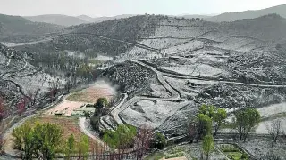 Un manto de granizo cubrió ayer las tierras quemadas en la localidad zaragozana de Moros.