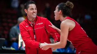 Víctor Lapeña sonríe junto a una jugadora de Canadá.