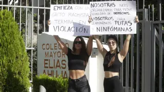 Dos chicas protestan en la puerta del colegio mayor Elías Ahuja.