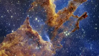 Los Pilares de la Creación se destacan en un caleidoscopio de color en la vista de luz infrarroja cercana del Telescopio Espacial James Webb de la NASA