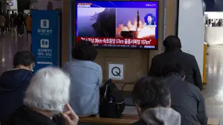 Varios ciudadanos siguen por televisión desde Seúl el lanzamiento de los misiles