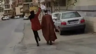 Una joven le quita el gorro a un clérigo en uno de los vídeos que circulan por Twitter.