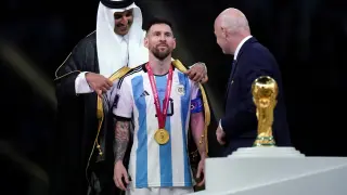 El emir de Qatar, el jeque Tamim bin Hamad Al Thani viste a Lionel Messi de Argentina con bisht árabe tradicional antes de entregarle la copa de campeón del mundo