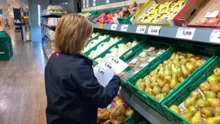 Una empleada de un supermercado cambia las etiquetas a primera hora de la mañana de este martes.