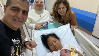 El cirujano Ramón Sousa, uno de los impulsores del proyecto, con una madre y su bebé en Filipinas a finales del pasado octubre.