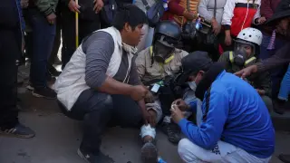 Varios hombres ayudan al fotógrafo de la Agencia EFE Aldair Mejía