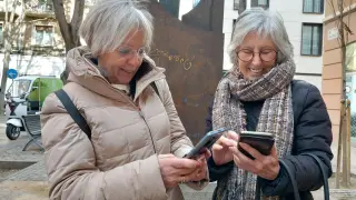 Marisa Gracia y Teresa Mainar, con sus teléfonos móviles en el centro de Zaragoza.