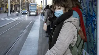 Varios pasajeros esperan el tranvía, este jueves, en el paseo de la Independencia de Zaragoza con la mascarilla puesta