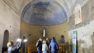 Autoridades y vecinos observan las pinturas murales templarias de Cofita