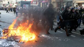 Varios policías tratan de atajar una de las protestas en París contra la reforma de las pensiones planteada por el Gobierno de Macron.