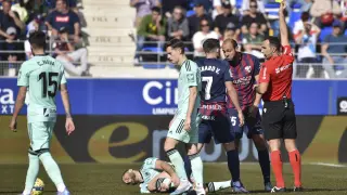 El árbitro Arcediano Monescillo muestra una tarjeta amarilla a los jugadores del Huesca durante el partido del Granada.