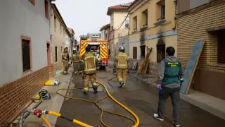 Bomberos y guardias civiles trabajan tras declararse un incendio que ha acabado con la vida de dos personas, en Cabañas de Ebro.