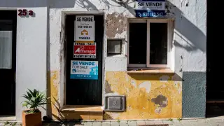 Una foto de archivo de una casa en la que se cuelga el cartel de "se vende".