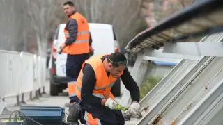 Los operarios trabajan para reparar los elementos metálicos de la pasarela el Voluntariado de Zaragoza.