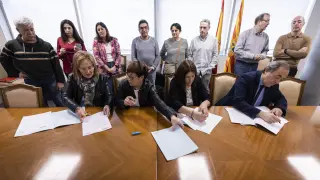 Las representantes sindicales y el gerente del Salud firman el acuerdo, ante el comité de huelga.