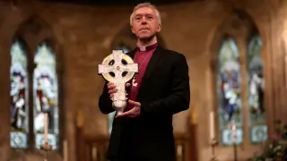 El arzobispo de Gales, Andrew John, posa con la cruz