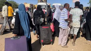 Varias personas esperan en la estación de autobuses de Jartum para escapar de la ciudad.