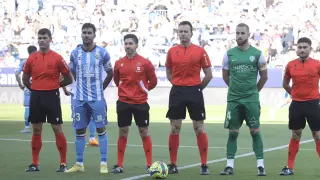 Los capitanes y el equipo arbitral del Málaga-Huesca