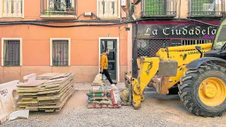 Un vecino camina por la acera frente a material de obra en la calle de Concepción Arenal de Zaragoza