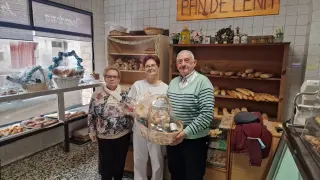 Elena Gratiela Croia (en el centro), con unos clientes, en su panadería de Fuentes de Ebro.