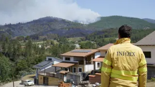 Un hombre observa el humo del fuego que afecta a la población de Pinofranqueado, Extremadura.