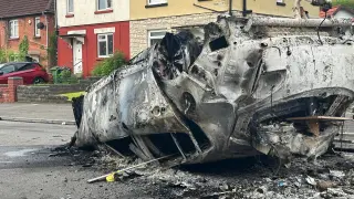 Un coche quemado tras los disturbios en Cardiff