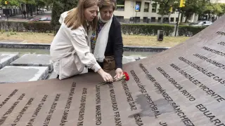 María Saz y su hija Sandra colocan dos claveles del ramo donde está el nombre de su familiar, el brigada Sergio López Saz, en el monumento del paseo Constitución.