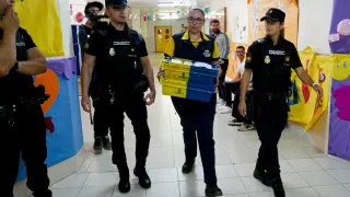Dispositivo de Seguridad en Colegio León Solá de Melilla, en el que varios agentes escoltan a la funcionaria de Correos a la mesa electoral para entregar los votos por correo.