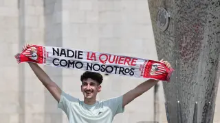Un seguidor del Sevilla FC posa junto a una réplica del trofeo de la Europa League en Budapest.