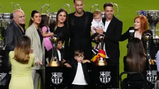 El futbolista del FC Barcelona, Sergio Busquets (c), acompañado por su familia durante la despedida ofrecida hoy miércoles al centrocampista blaugrana en el estadio del Camp Nou, en Barcelona.