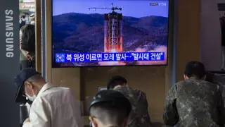 Varias personas, en Seúl delante de una televisión que informa del supuesto lanzamiento de un cohete espía de Corea del Norte.