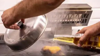 La 'cheeseburger' se hace derritiendo el queso cheddar inglés con el vapor de cerveza.