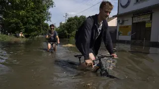 Unos jóvenes ucranianos tras las inundaciones por la presa de Kajovka.