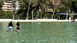 Algunas personas bañándose en el lago, recién inaugurado, situado en la ampliación del parque de Pignatelli de Zaragoza.
