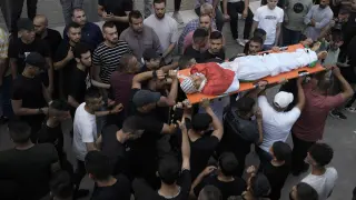 Familiares llevan el cuerpo de Ahmed Saqr, de 15 años, muerto en combates entre militantes palestinos y fuerzas israelíes, en la ciudad cisjordana de Yenin