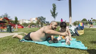 Un padre echa crema solar a su hijo, ayer, en las piscinas de Ciudad Jardín
