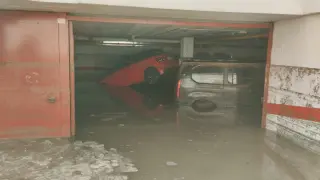 Dos coches flotan en el interior de un garaje de Cuarte de Huerva, inundado tras la tormenta de este jueves.