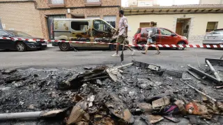 Coches dañados tras la quema de contenedores en el barrio Oliver, este lunes en Zaragoza.