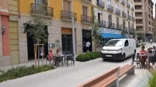 Una furgoneta, pasando en dirección prohibida entre las dos zonas de terraza adjudicadas al restaurante.