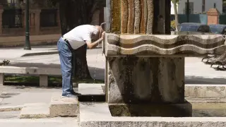 Un vecino de Teruel se refresca en la fuente de Torán.