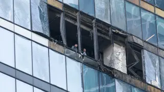 Dos policías moscovitas examinan los daños producidos por un dron en un edificio de la city de Moscú.