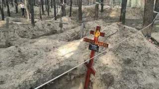 Una cruz recuerda a uno de los 449 ucranianos que murieron durante la ocupación rusa de la ciudad de Izium y fueron enterrados en la fosa común
