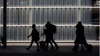 Varias personas caminan con su equipaje en el Aeropuerto de Barcelona-El Prat.